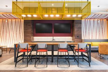 A dining room with a table and chairs and a wall with a tv